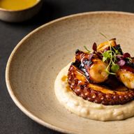 Smoky Bourbon-Glazed Charred Octopus over Silken White Bean Purée photo 1